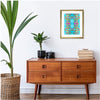 modern tropical artwork with a 60s vibe in a modern house with plants and a cabinet