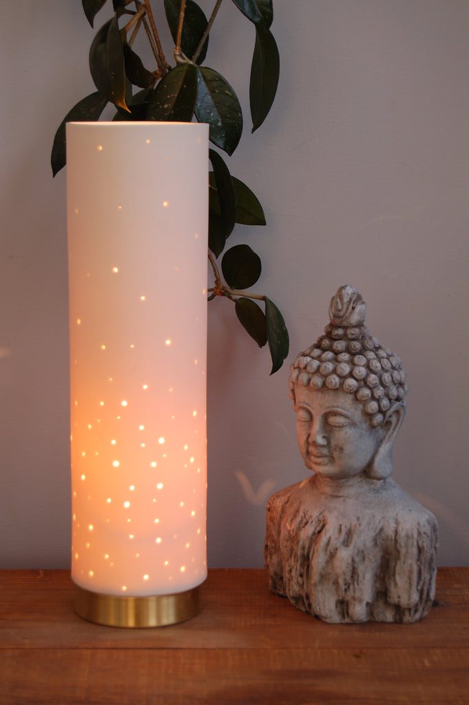 Glowing lamp beside Buddha statue