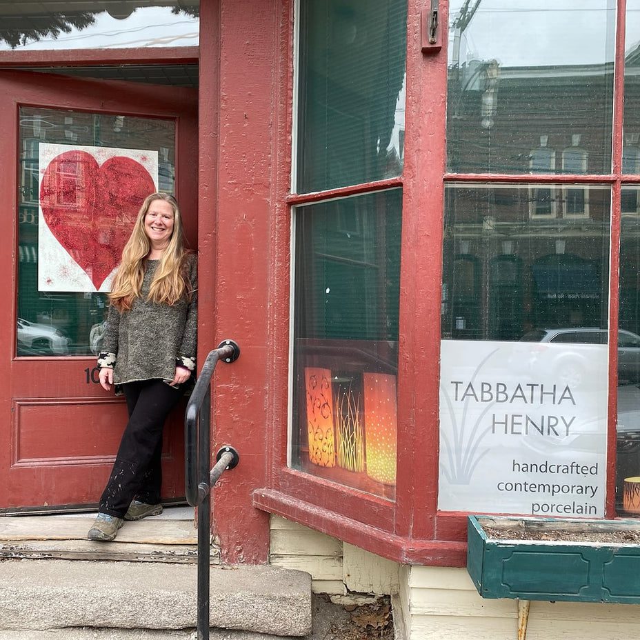 Woman standing outside a red storefront
