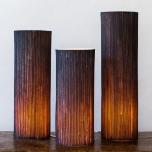 Three glowing cylindrical lampshades