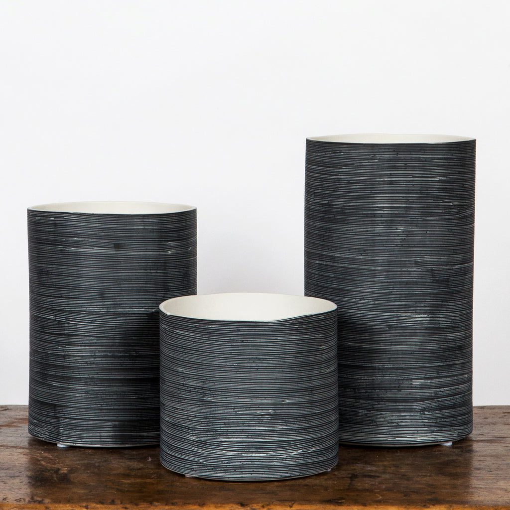 Modern black vases in varying heights.