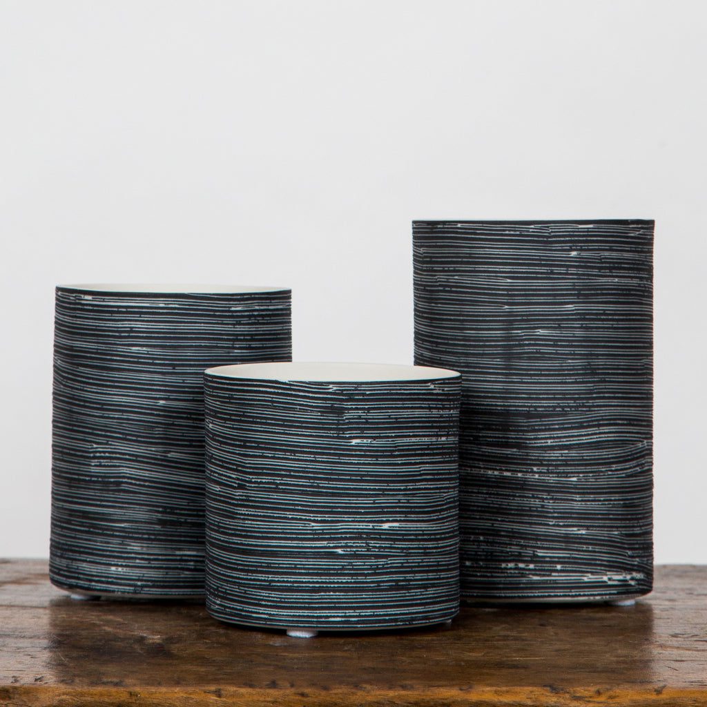 Striped ceramic vases on wooden table