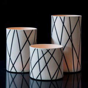 Modern cylindrical vases on black background