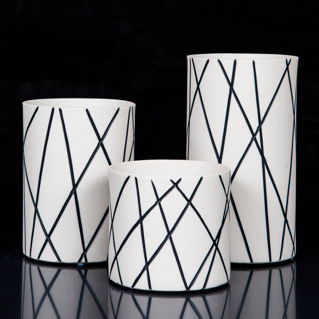 Three modern cylindrical vases on display