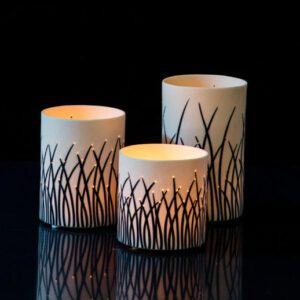 Elegant candles reflecting on black surface