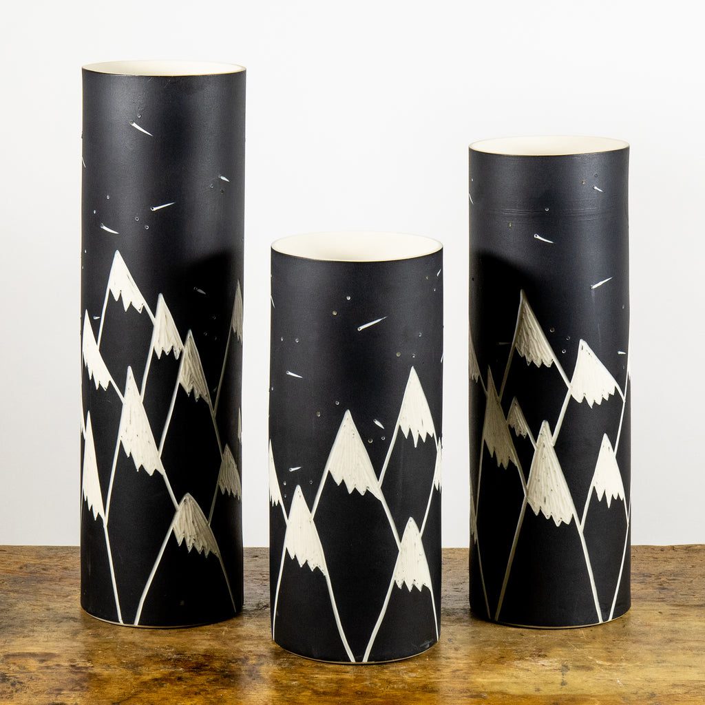 Three decorative vases on wooden surface