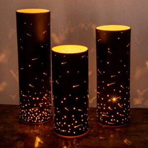 Three illuminated cylindrical lights on table