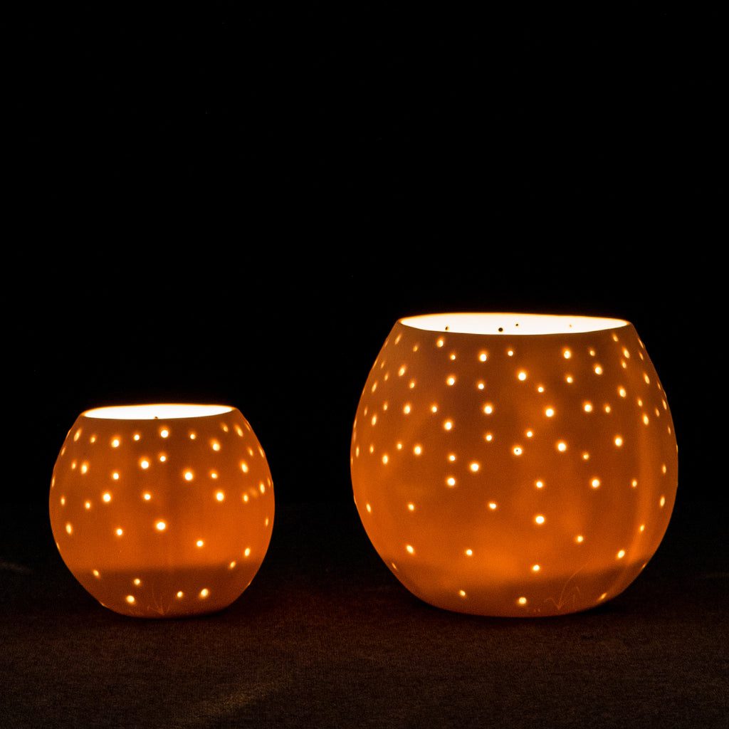 Lit ceramic candle holders with holes