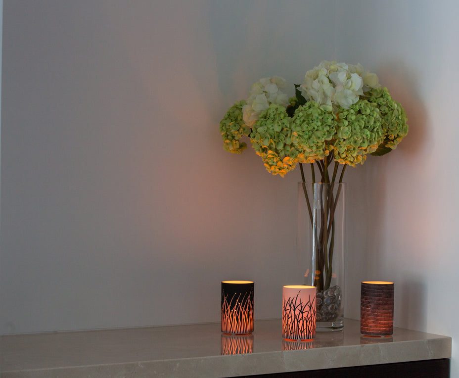 Vase with hydrangeas and lit candles