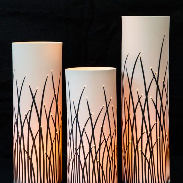 Three cylindrical lamps with glowing patterns