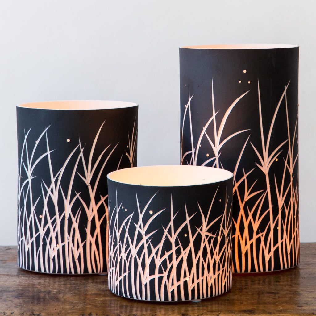 Elegant cylindrical lamps on wooden table