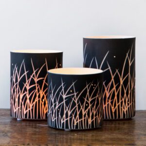 Three cylindrical lamps on wooden table