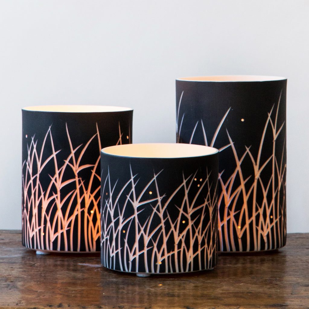 Three cylindrical lamps on wooden table