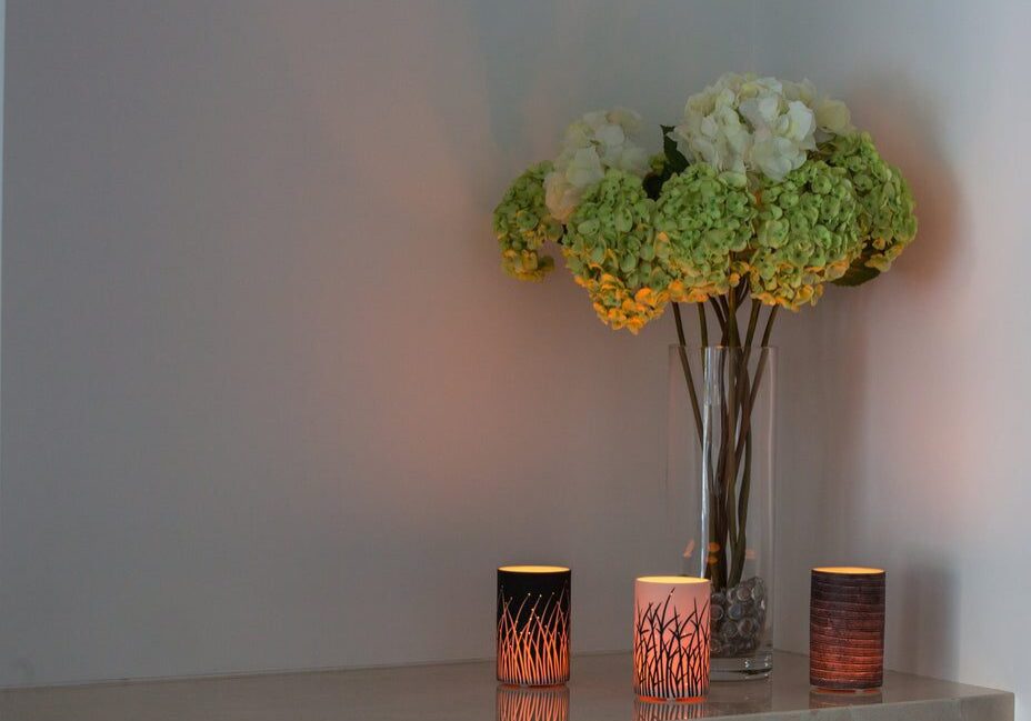 Vase with hydrangeas and lit candles